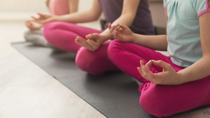 Closeup av moder- och döttrarhänder som gör yogaövning och stretching hemma. Hälsa, sport, leasure-koncept